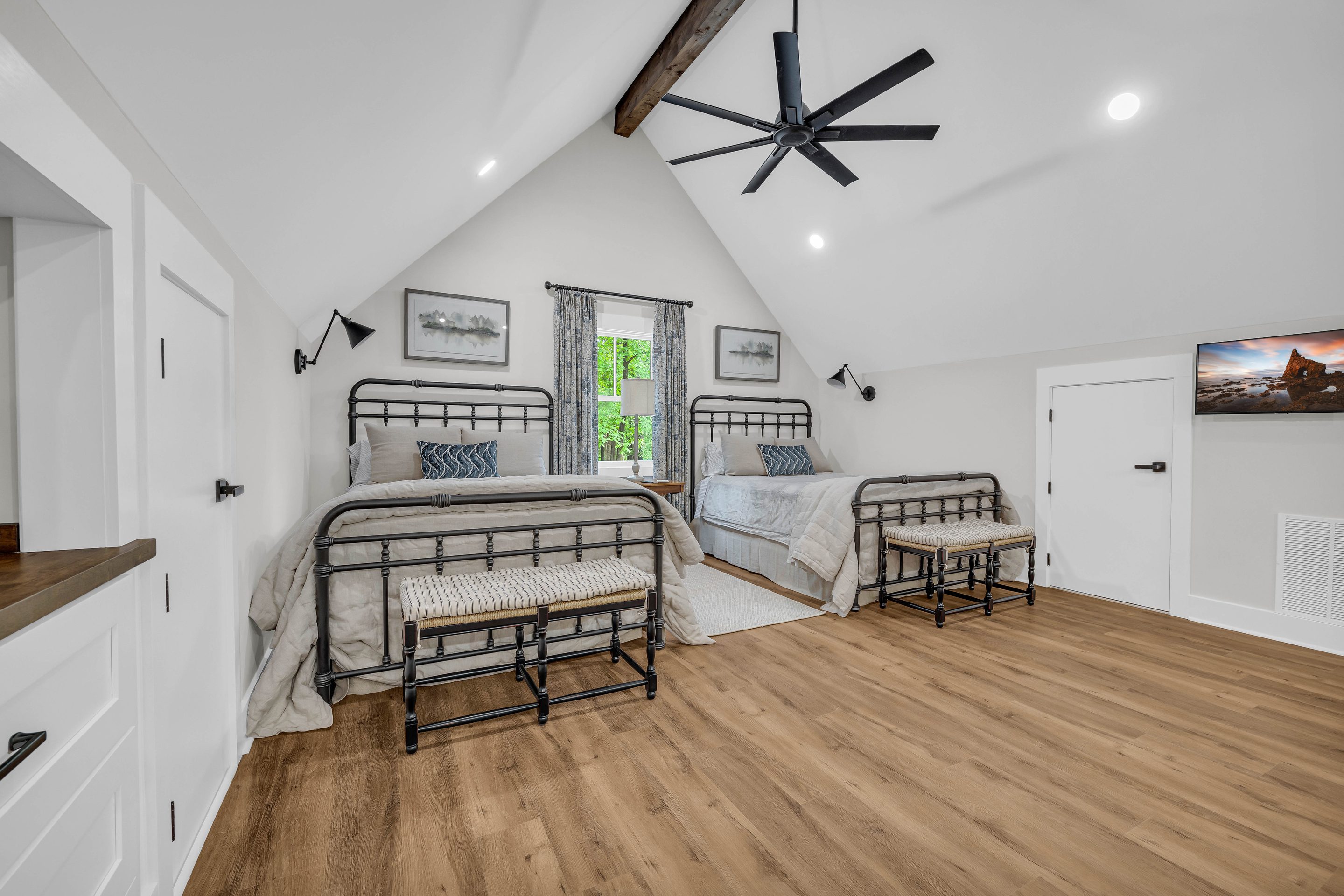 A bedroom with two beds and a window.
