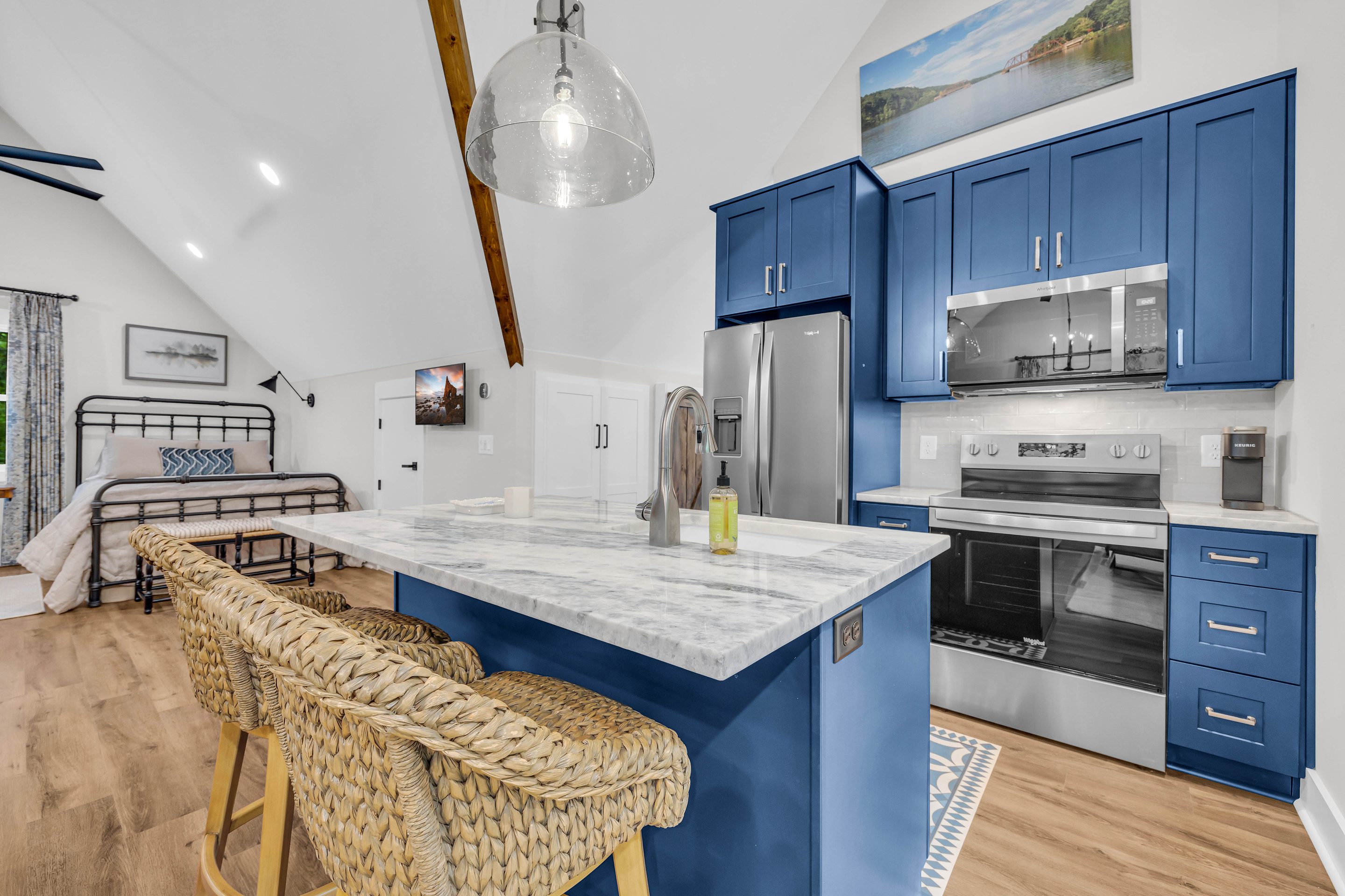 A kitchen with blue cabinets and white counter tops.